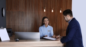 Una recepcionista atiende a un cliente en un hotel