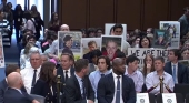 Dave Calhoun, CEO de Boing, -abajo a la izquierda- observa las fotografías de las víctimas mortales de los accidentes de los 737 MAX 8, exhibidas por sus familiares en el Senado de EE. UU.