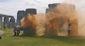Una persona intenta detener a uno de los activistas de Just Stop Oil que vandalizaron el monumento megalítico de Stonehenge (Reino Unido) | Foto: Just Stop Oil