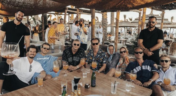 Erling Haland (tercero por la izda., sentado) con sus amigos en el 'beach club' Playa Padre, en Marbella (Madrid)